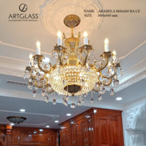 Hình ảnh thực tế đèn chùm đồng pha lê Artglass ARABELA BRASS ANTIQUE, với thiết kế cổ điển và màu đồng giả cổ, được lắp đặt sang trọng trong không gian nội thất gỗ.